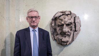 Carl Bildt in front of his portrait. 